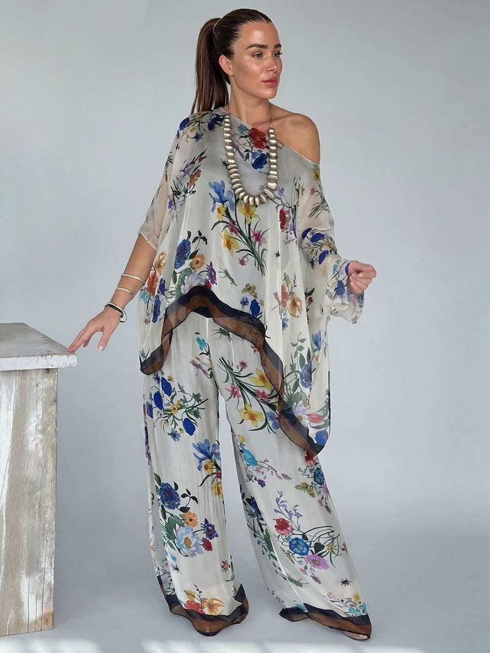 Ensemble élégant à imprimé floral et tissu transparent, composé d’un haut asymétrique à une épaule et d’un pantalon à jambes larges