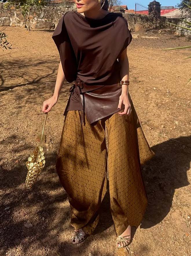 Completo elegante con top drappeggiato asimmetrico e pantaloni stampati a gamba larga, due pezzi