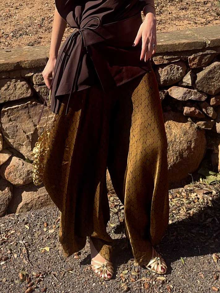 Completo elegante con top drappeggiato asimmetrico e pantaloni stampati a gamba larga, due pezzi