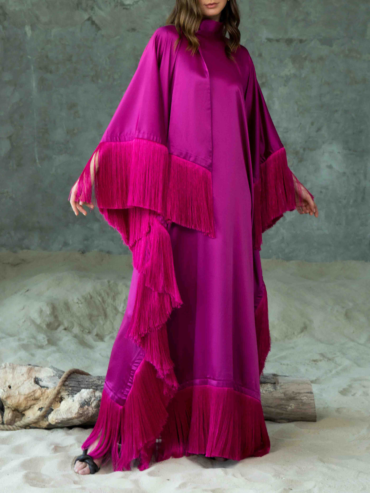 Elegante abito lungo asimmetrico a collo alto con finiture di frange