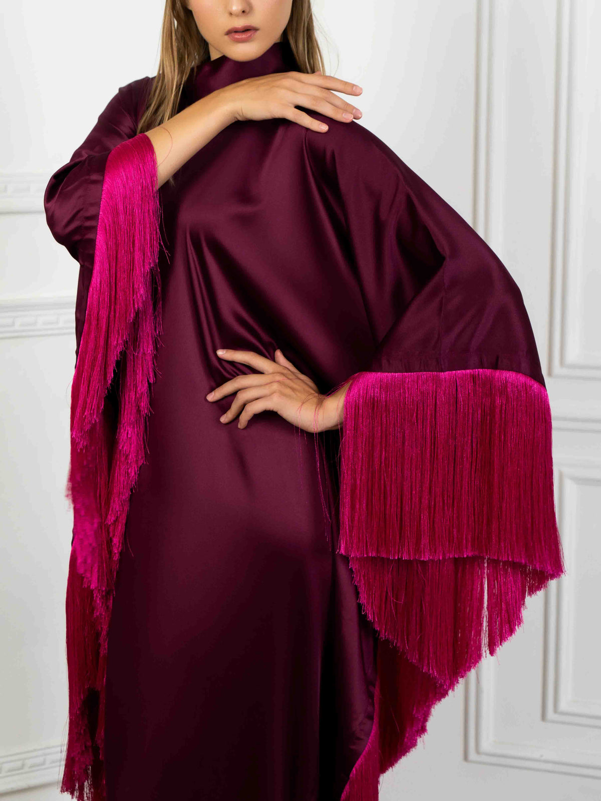Elegante abito lungo asimmetrico a collo alto con finiture di frange