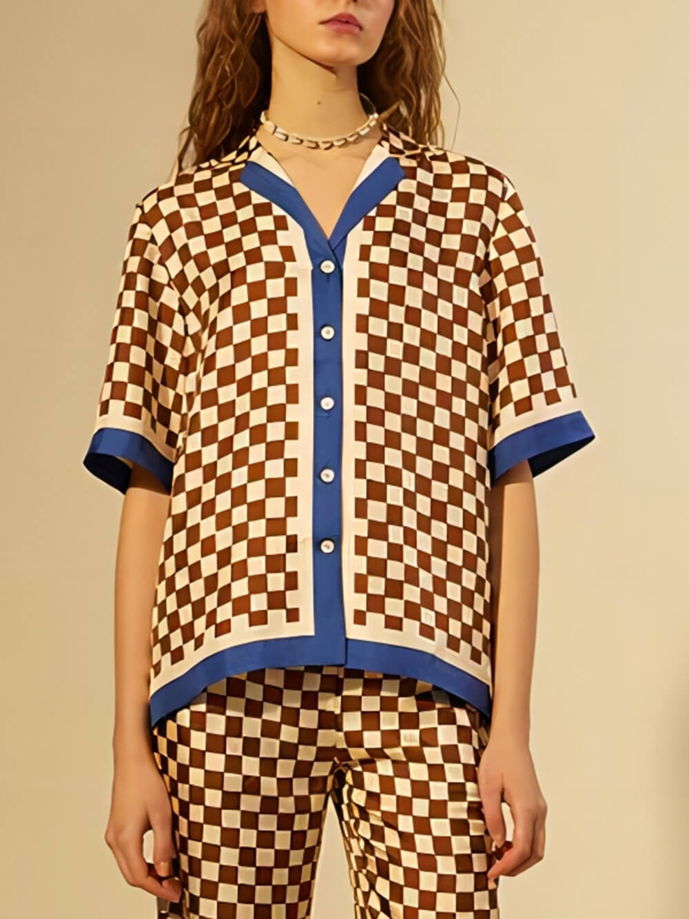 Top ampio originale con stampa a scacchiera e inserti a righe blu