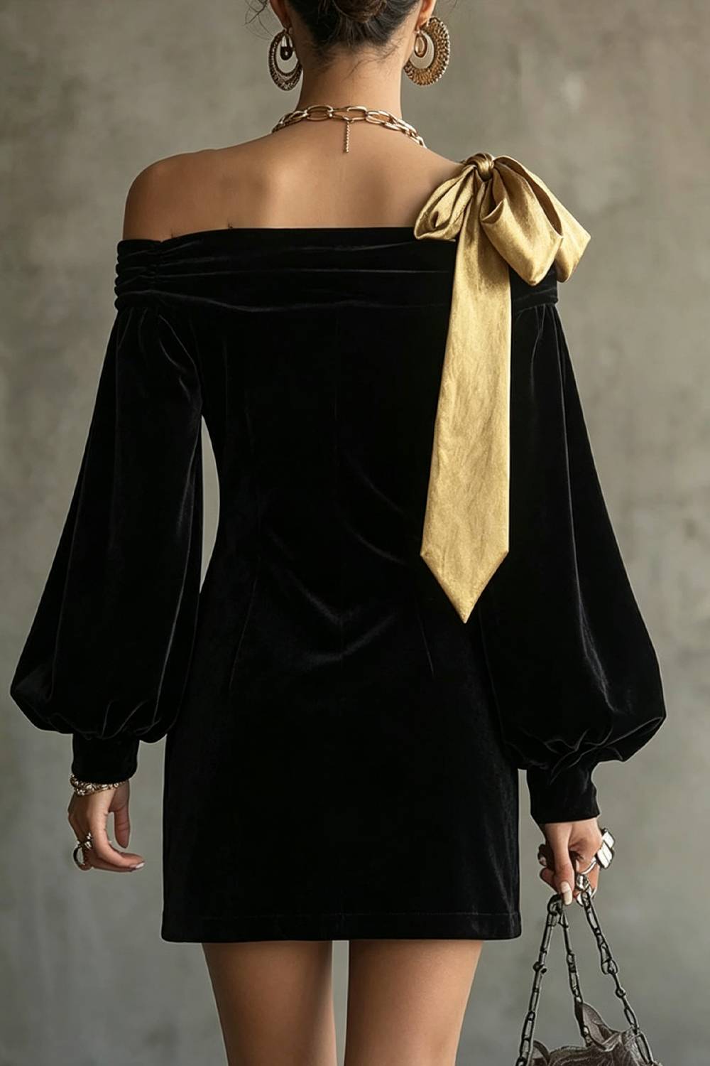 Vestido de festa mini justo ao corpo, com ombros descobertos, laço grande contrastante e mangas compridas bufantes