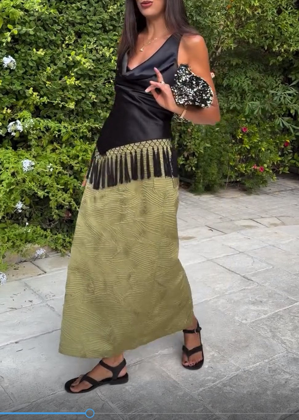 Ensemble deux pièces composé d’un caraco noir en satin à col bénitier et d’une jupe midi texturée olive à pampilles