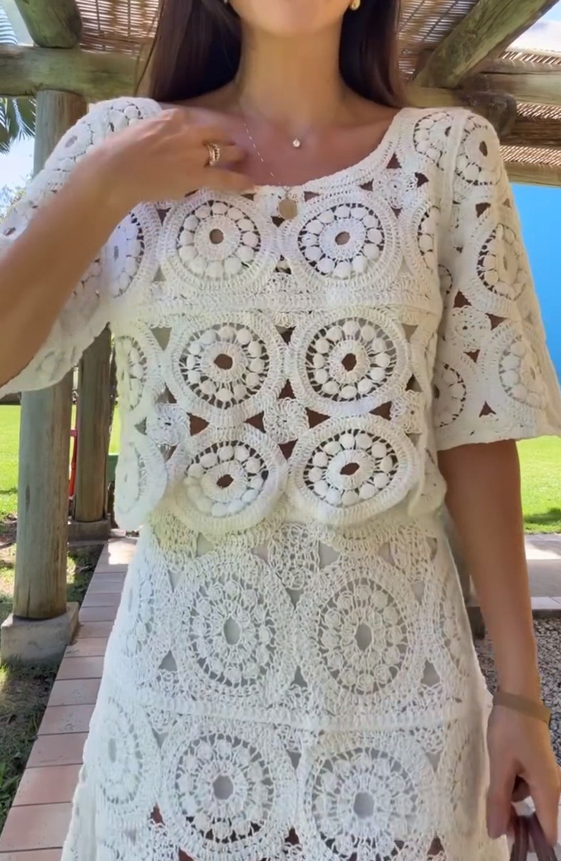 Ensemble deux pièces composé d’un haut blanc à manches courtes au crochet et d’une jupe mini