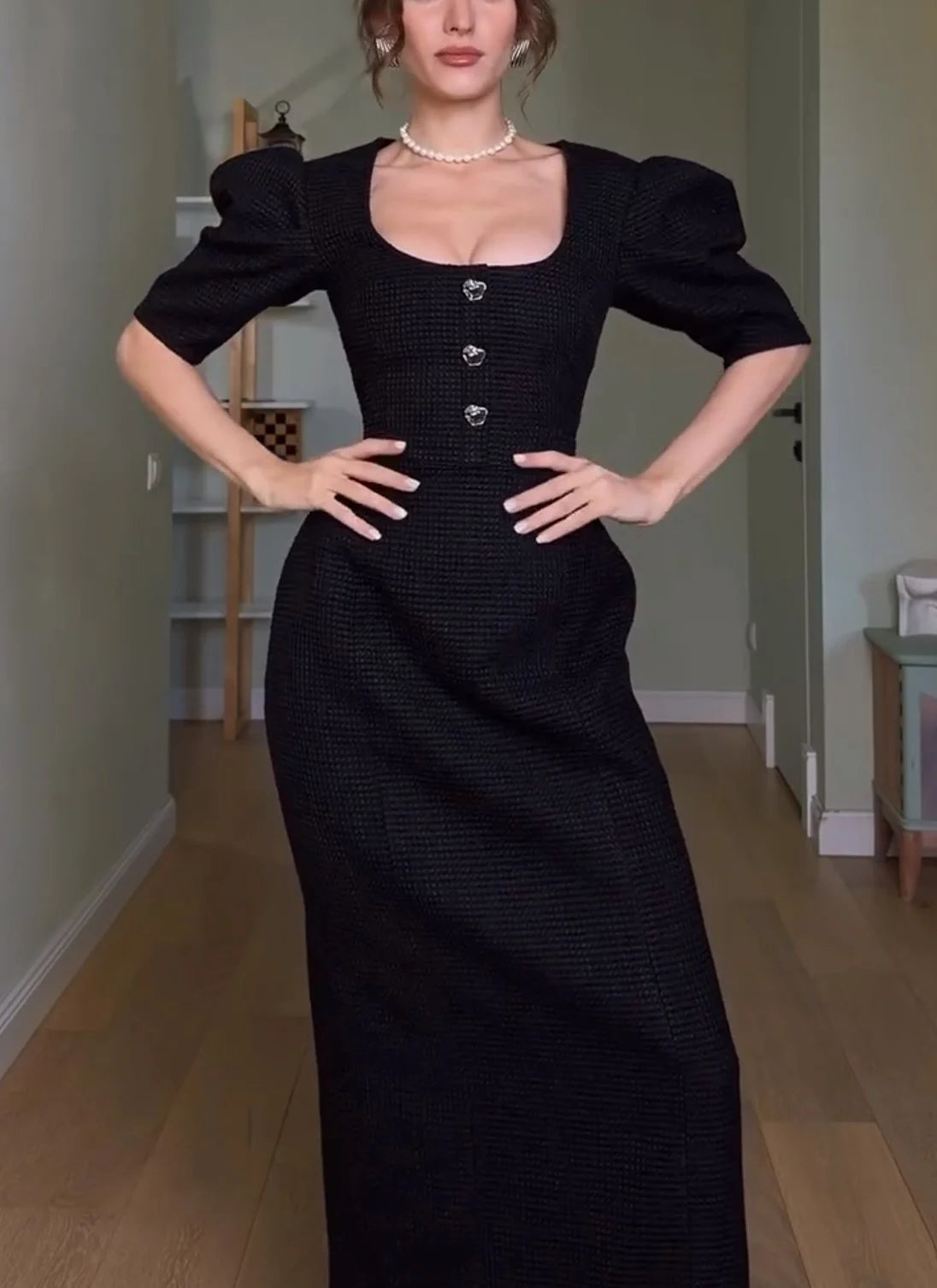 Vestido maxi preto de corte direito, com decote redondo, mangas tufadas e botões à frente