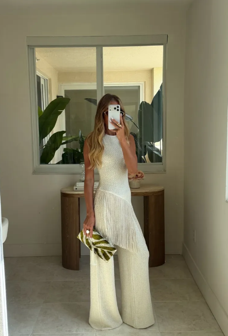Completo chic bianco con top all'uncinetto senza maniche e nappine, e pantaloni a gamba larga