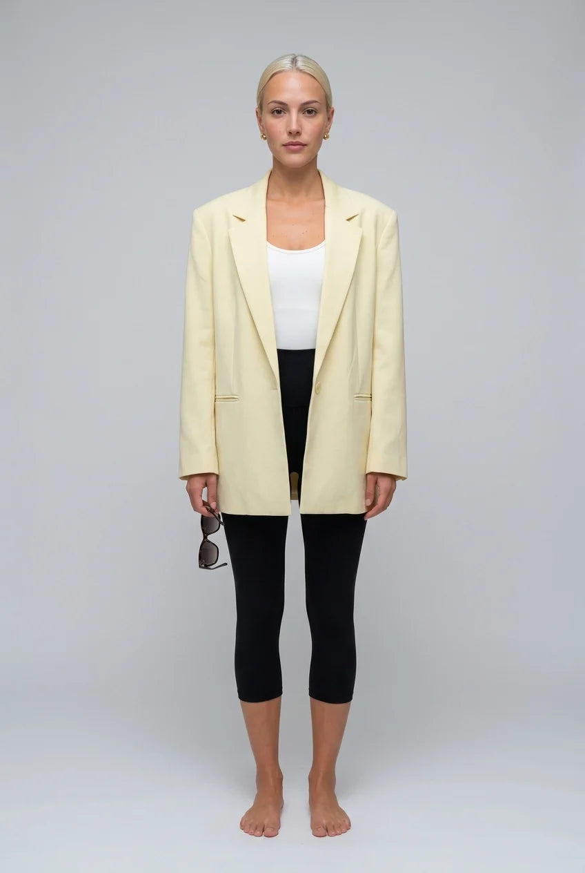 Blazer amarelo-claro oversized para mulher, com abotoamento simples e lapela entalhada