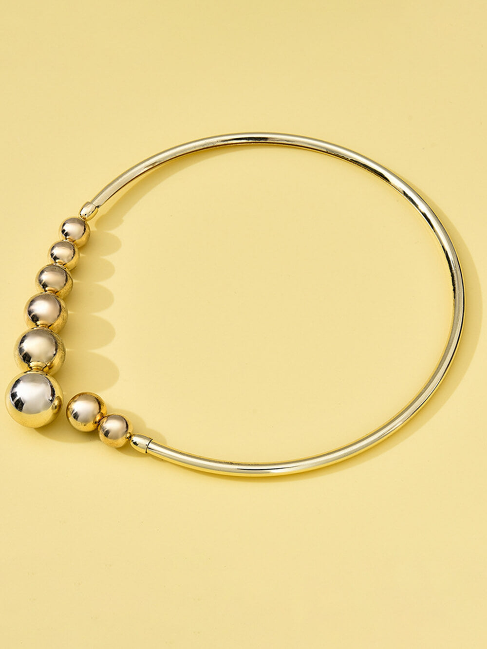 Collier raffiné à petites perles dorées et chaîne ouverte sur les clavicules