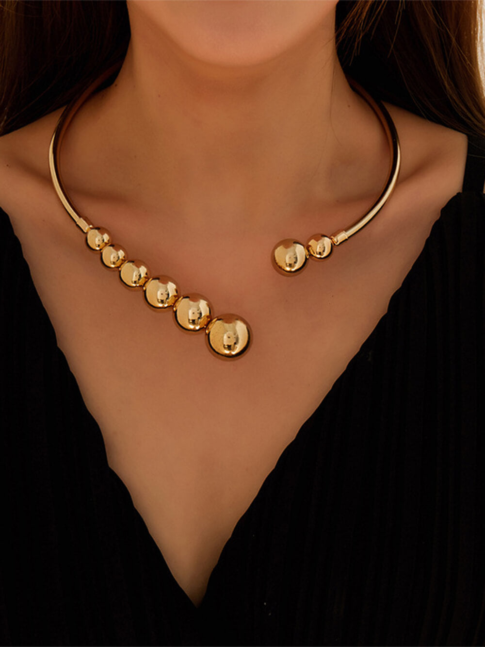 Collier raffiné à petites perles dorées et chaîne ouverte sur les clavicules