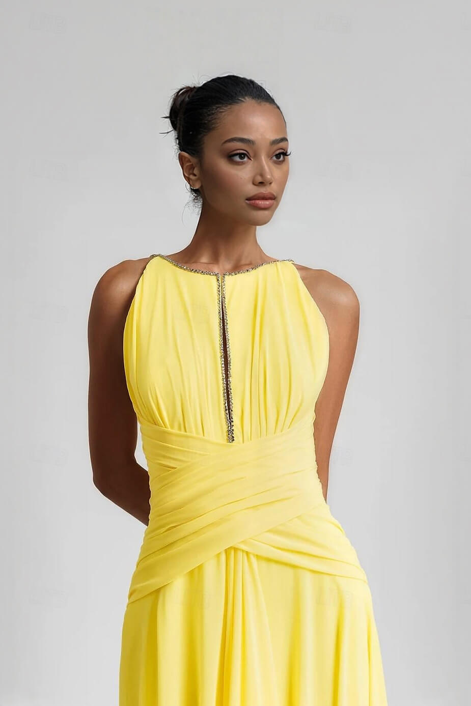 Elegante abito lungo a trapezio in chiffon plissettato senza maniche, impreziosito da strass