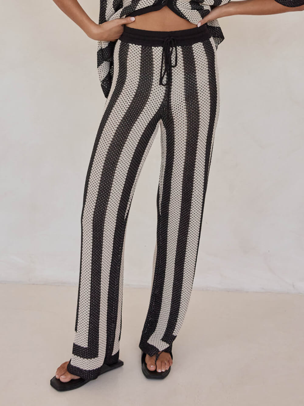 Pantalones tejidos a rayas negras y color arena