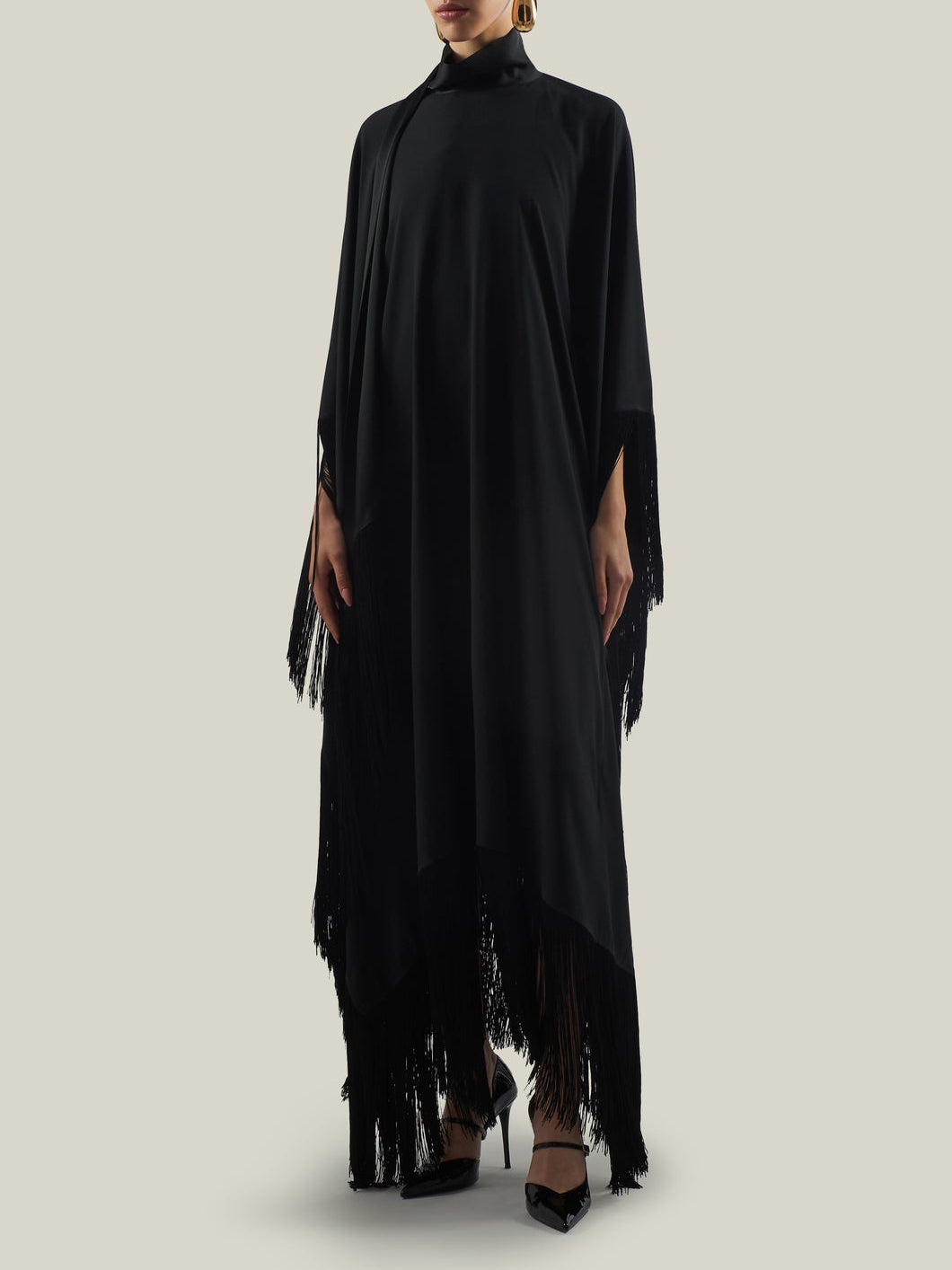 Elegante abito lungo asimmetrico a collo alto con finiture di frange
