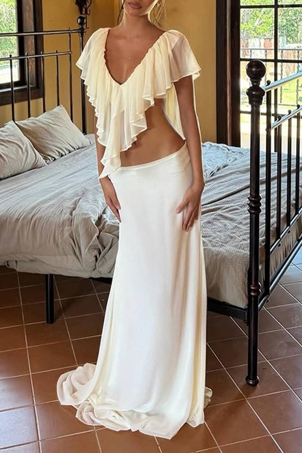 Completo due pezzi con top con scollo a V, volant e cut-out, e gonna lunga a sirena con strascico