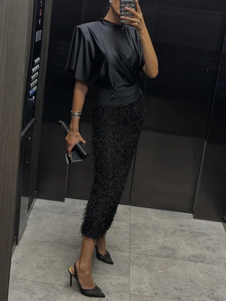 Elegante set a due pezzi con top in raso e gonna midi con paillettes e piume
