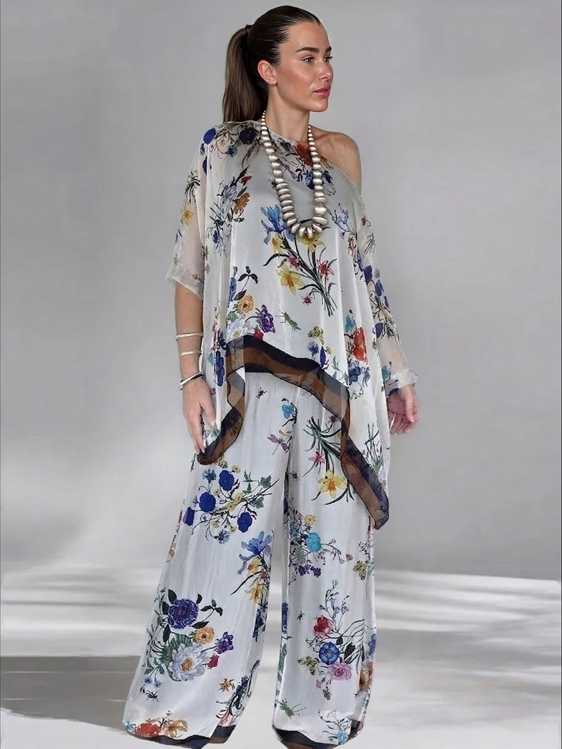 Conjunto elegante de top assimétrico de um ombro, em chiffon transparente com estampado floral, e calças de perna larga