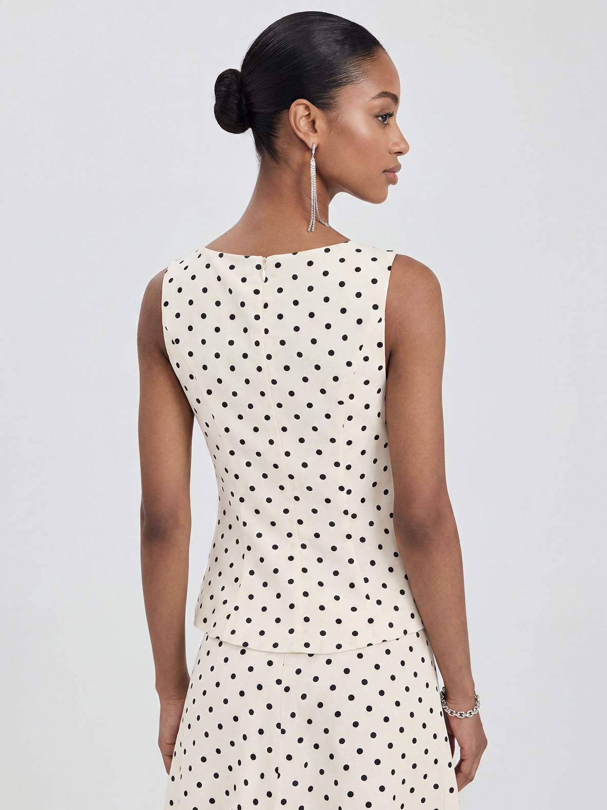 Elegante completo a due pezzi con top senza maniche e gonna a pois