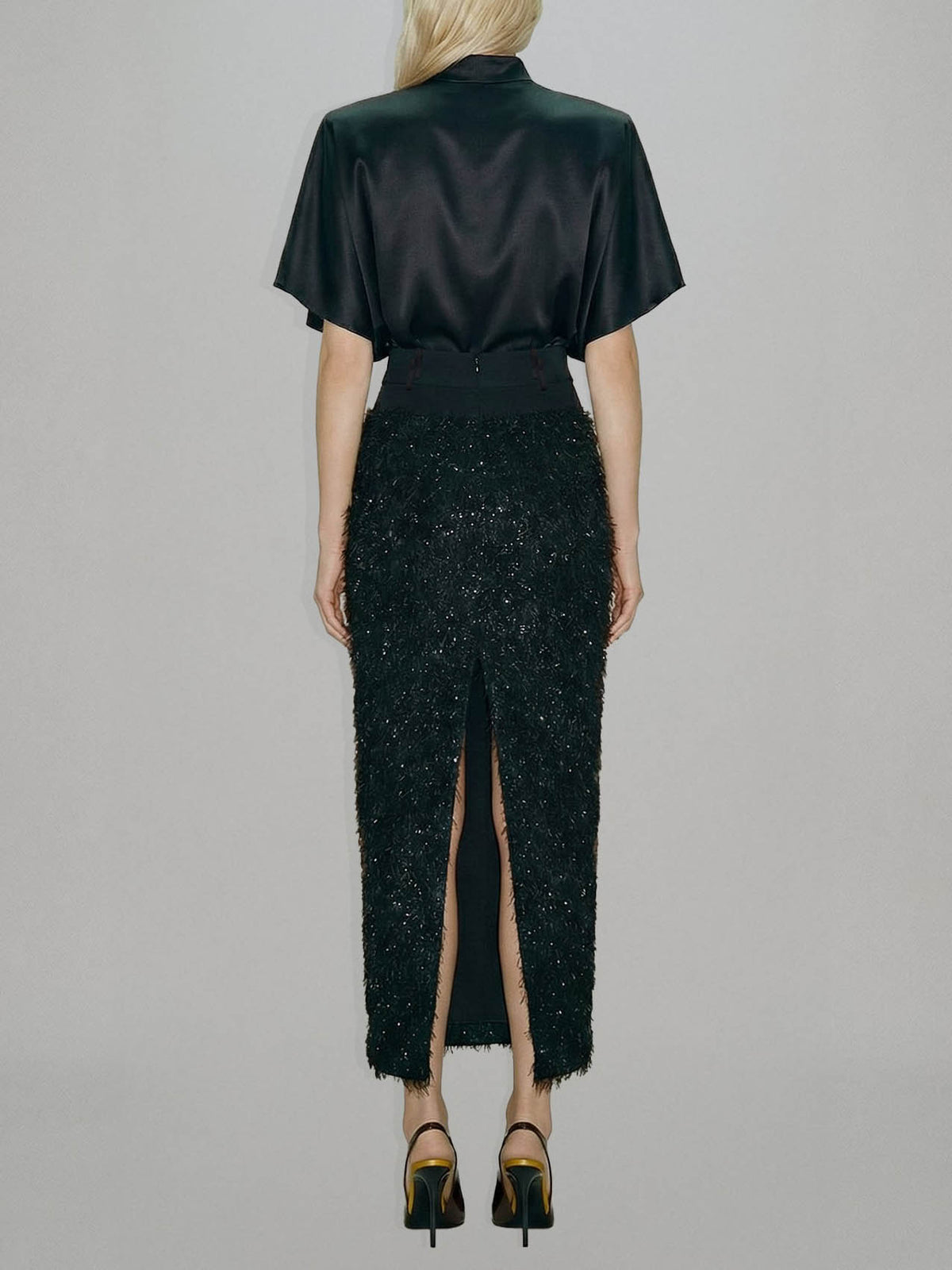 Elegante set a due pezzi con top in raso e gonna midi con paillettes e piume