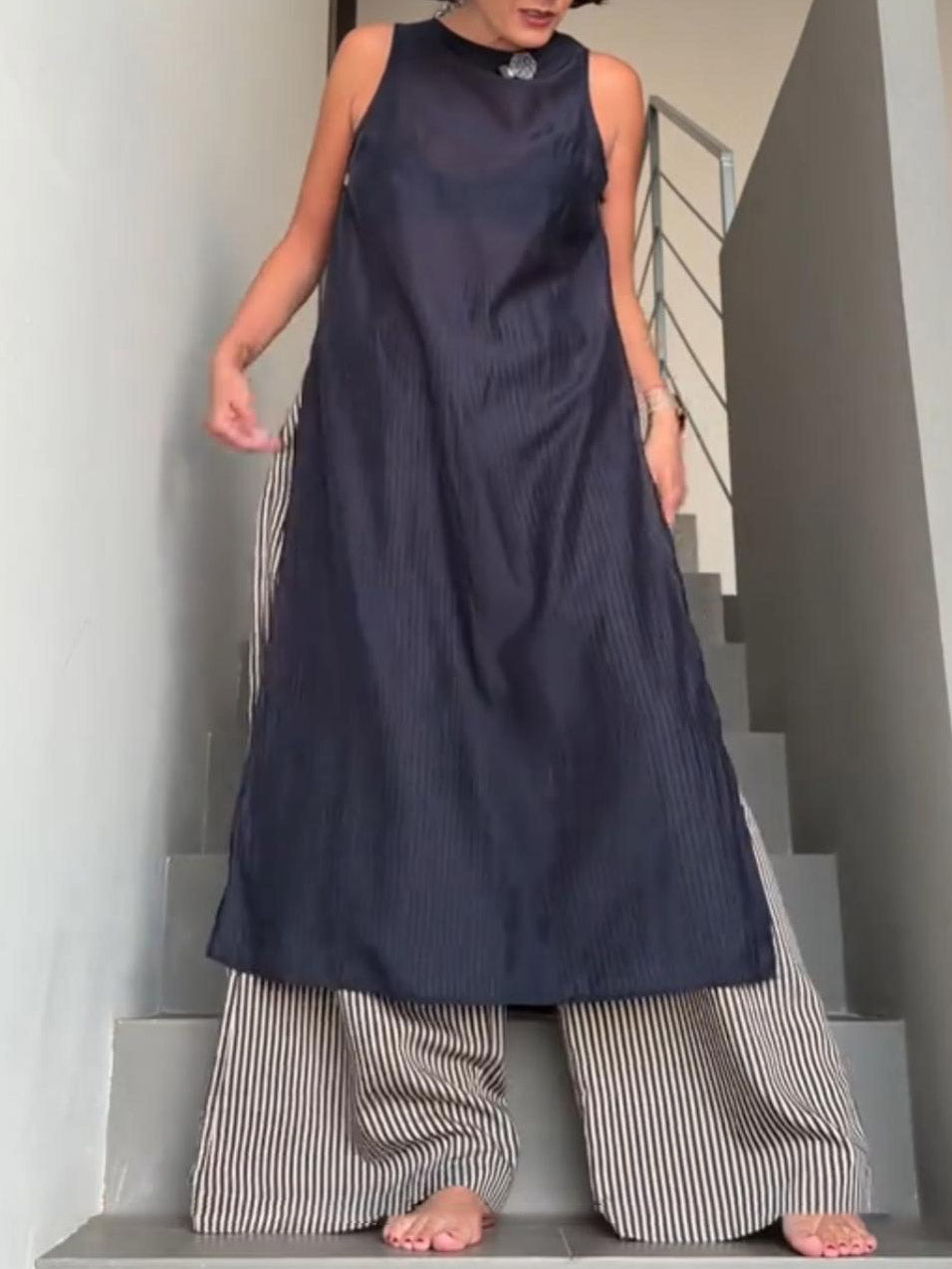 Minimalistisches zweiteiliges Set aus ärmellosem Longtop und gestreifter Hose mit weitem Bein