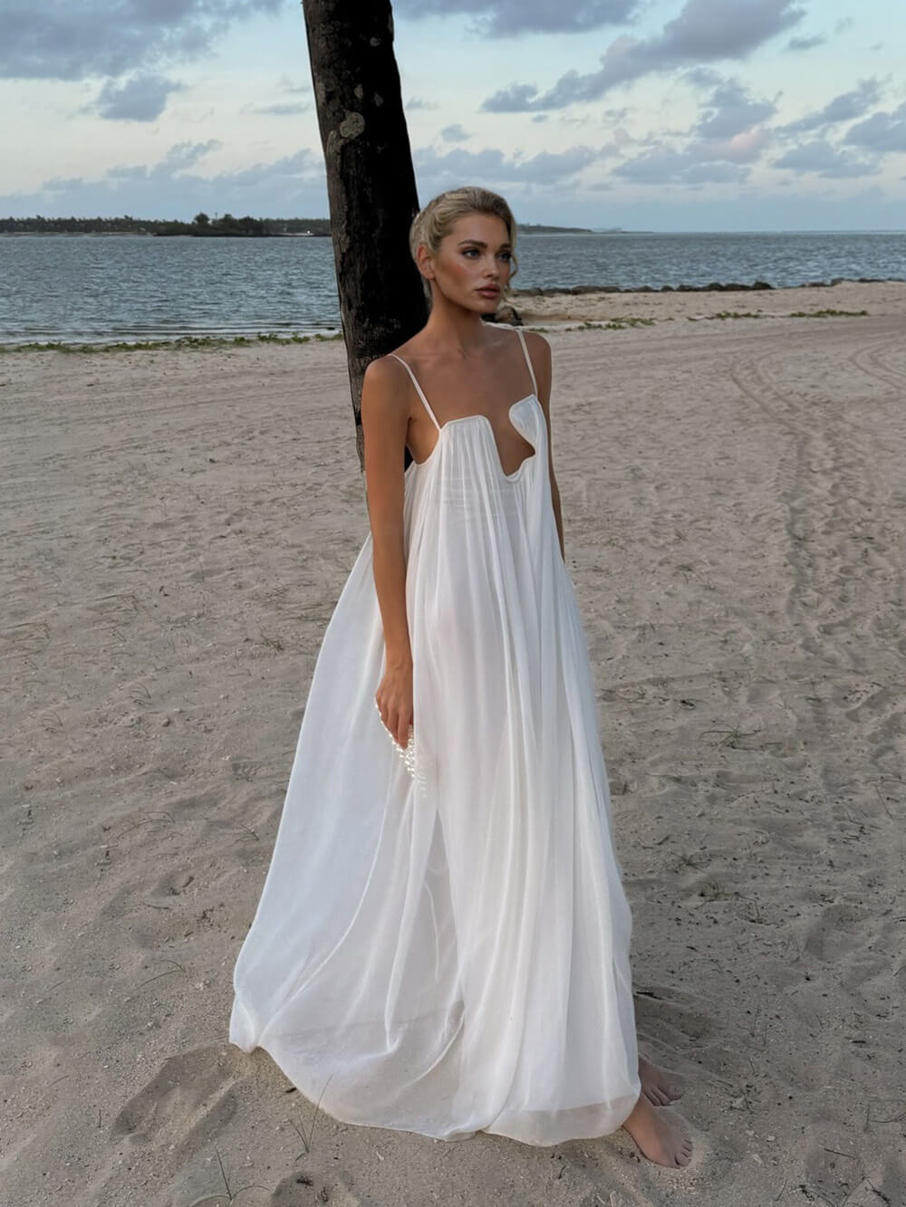 Elegante abito lungo ampio in chiffon, fluido, con scollo profondo e cut-out sul décolleté
