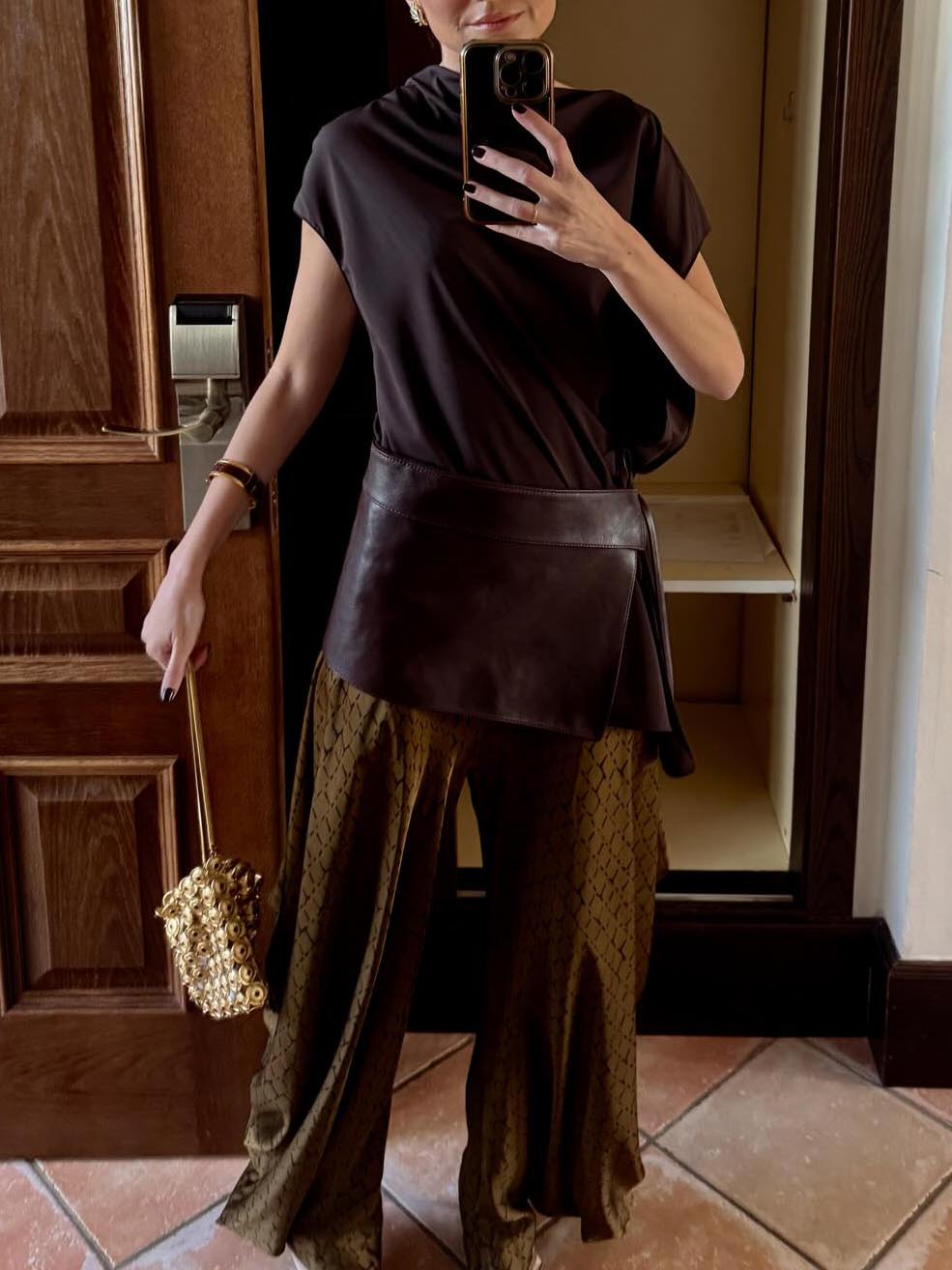 Completo elegante con top drappeggiato asimmetrico e pantaloni stampati a gamba larga, due pezzi