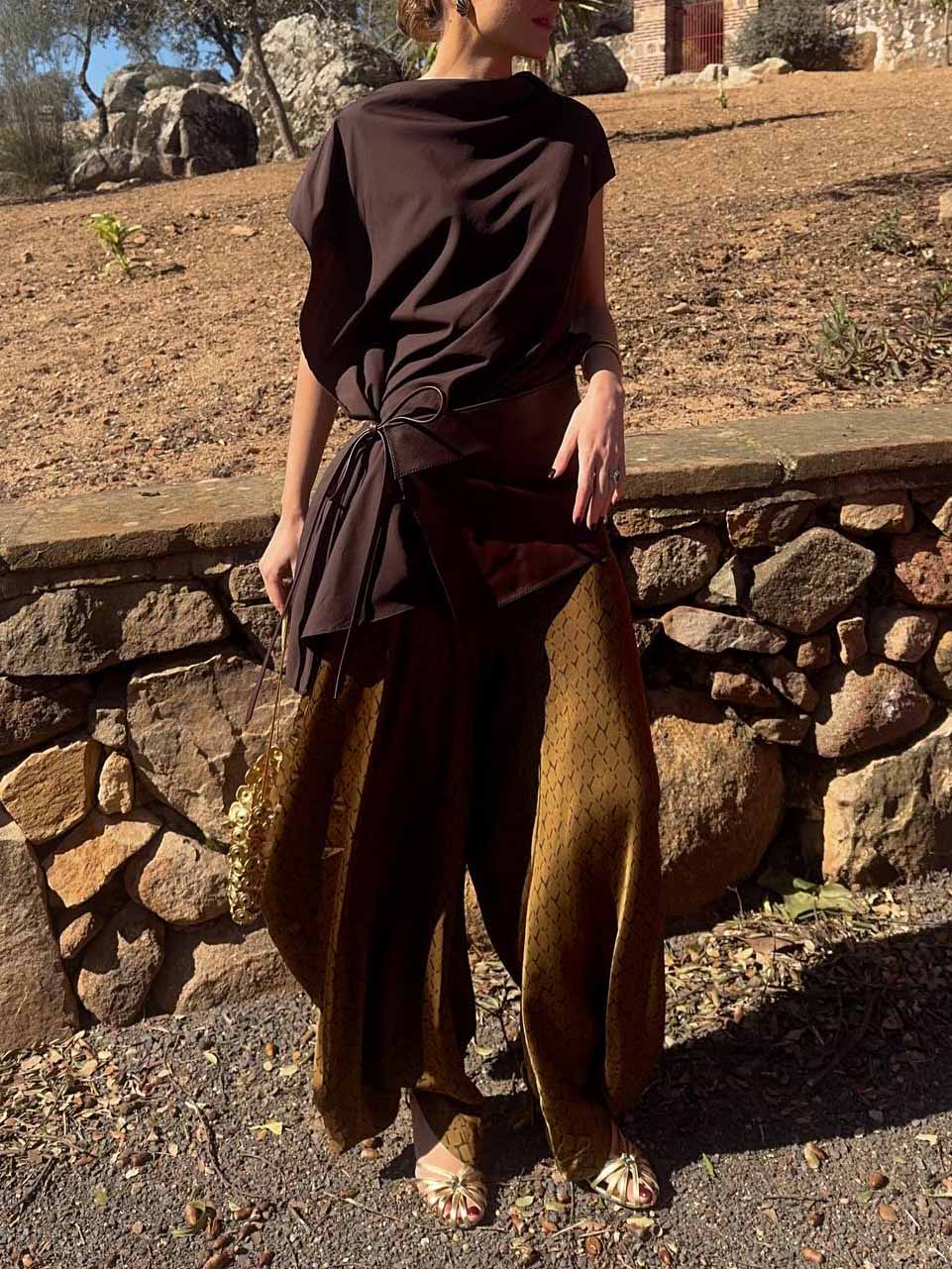 Completo elegante con top drappeggiato asimmetrico e pantaloni stampati a gamba larga, due pezzi