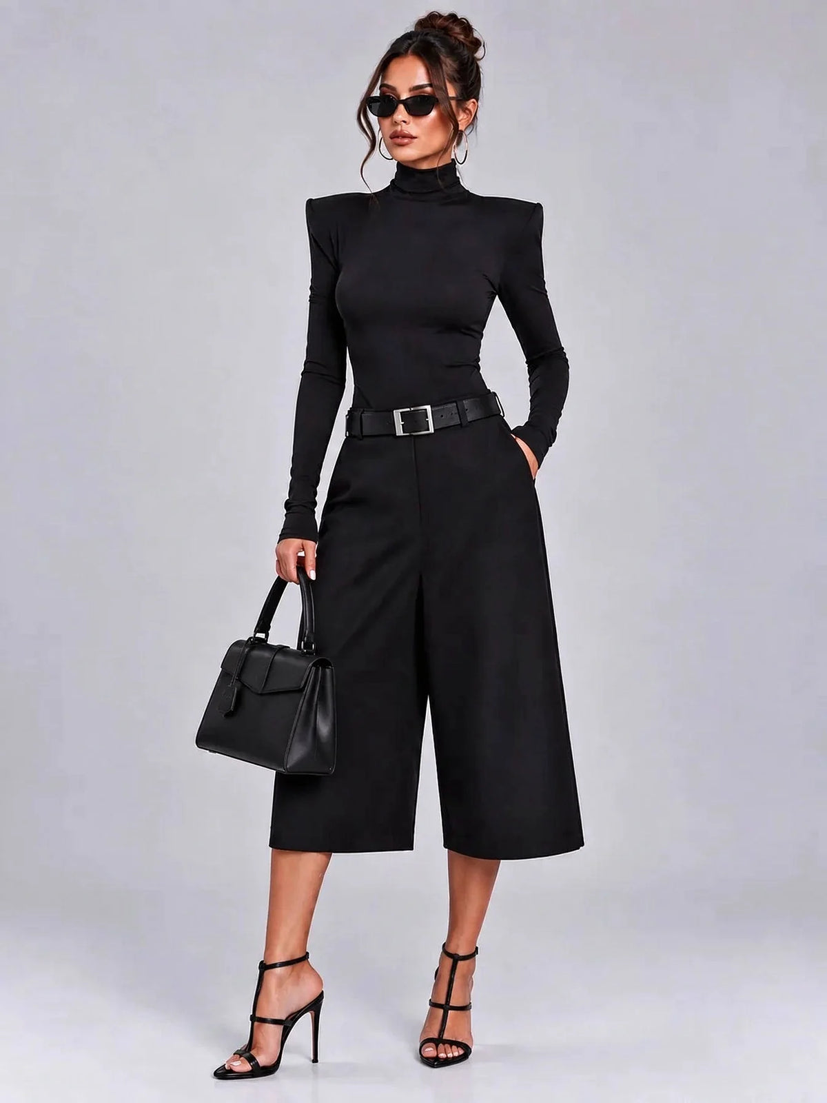 Ensemble deux pièces noir pour femme avec haut à manches longues, col montant et épaules rembourrées, et short bermuda