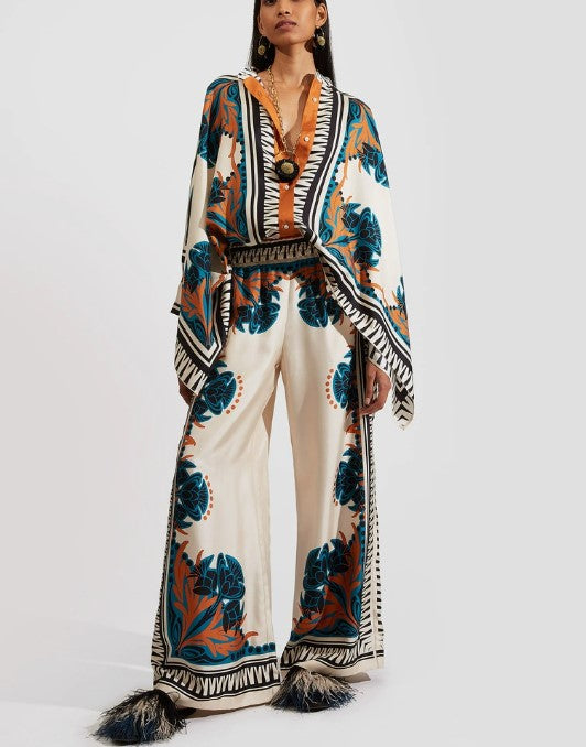 Completo due pezzi con top a mantella a V con stampa floreale esotica e pantaloni a gamba larga
