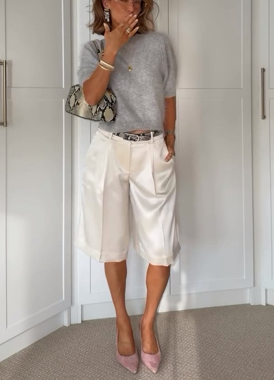 Zweiteiliges Outfit aus grauem Stricktop mit Raglanärmeln und weißer Satinhose mit weitem Bein
