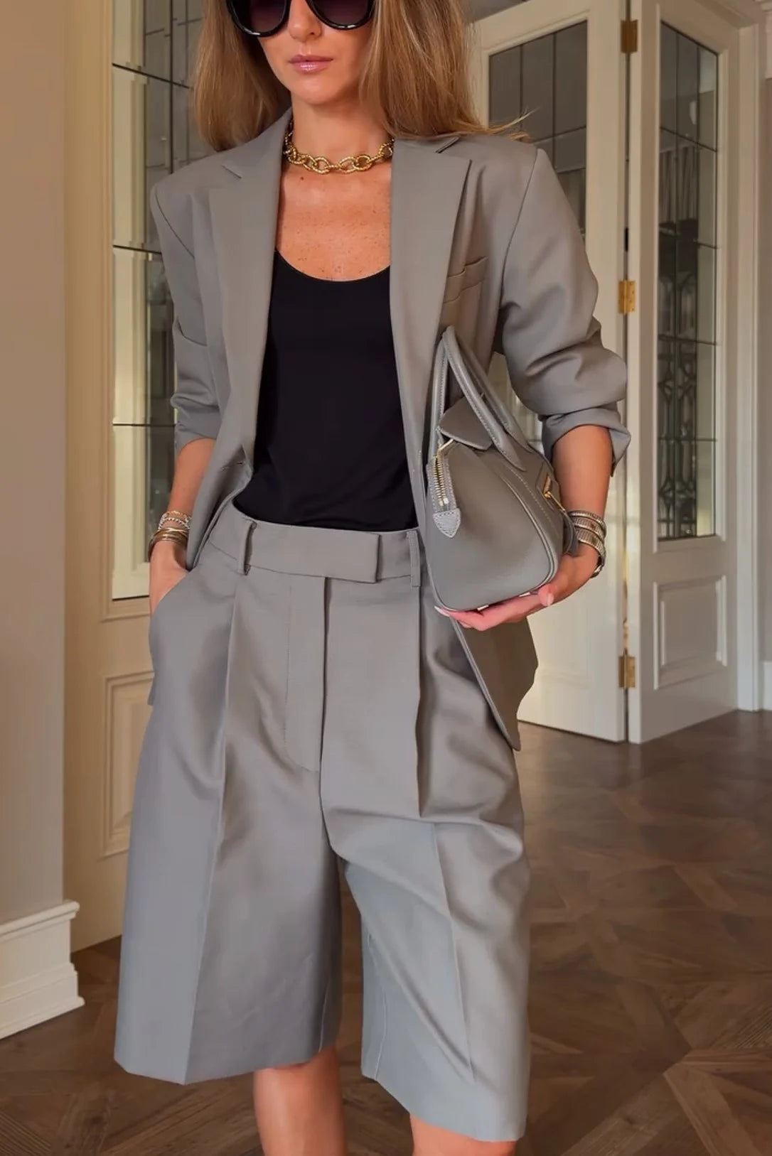 Ensemble tailleur deux pièces gris, avec blazer à boutonnage simple et bermuda plissé