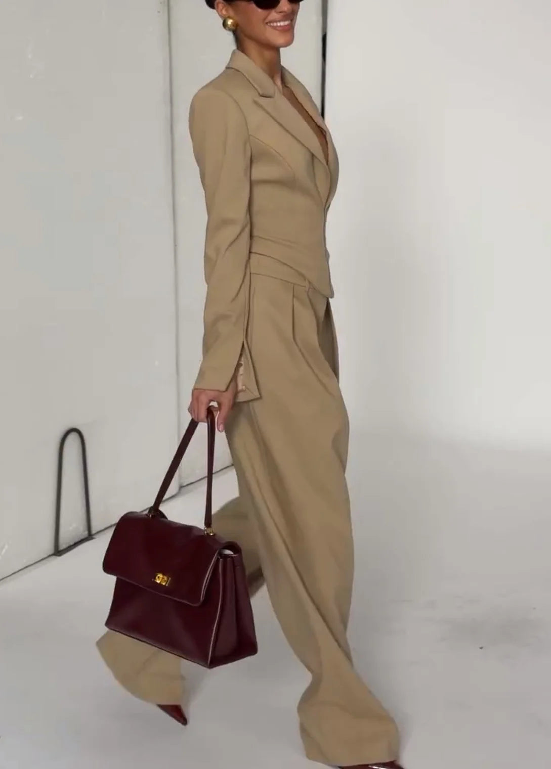 Zweiteiliges Set aus beigem Korsettblazer mit tiefem Revers und plissierter Hose mit weitem Bein