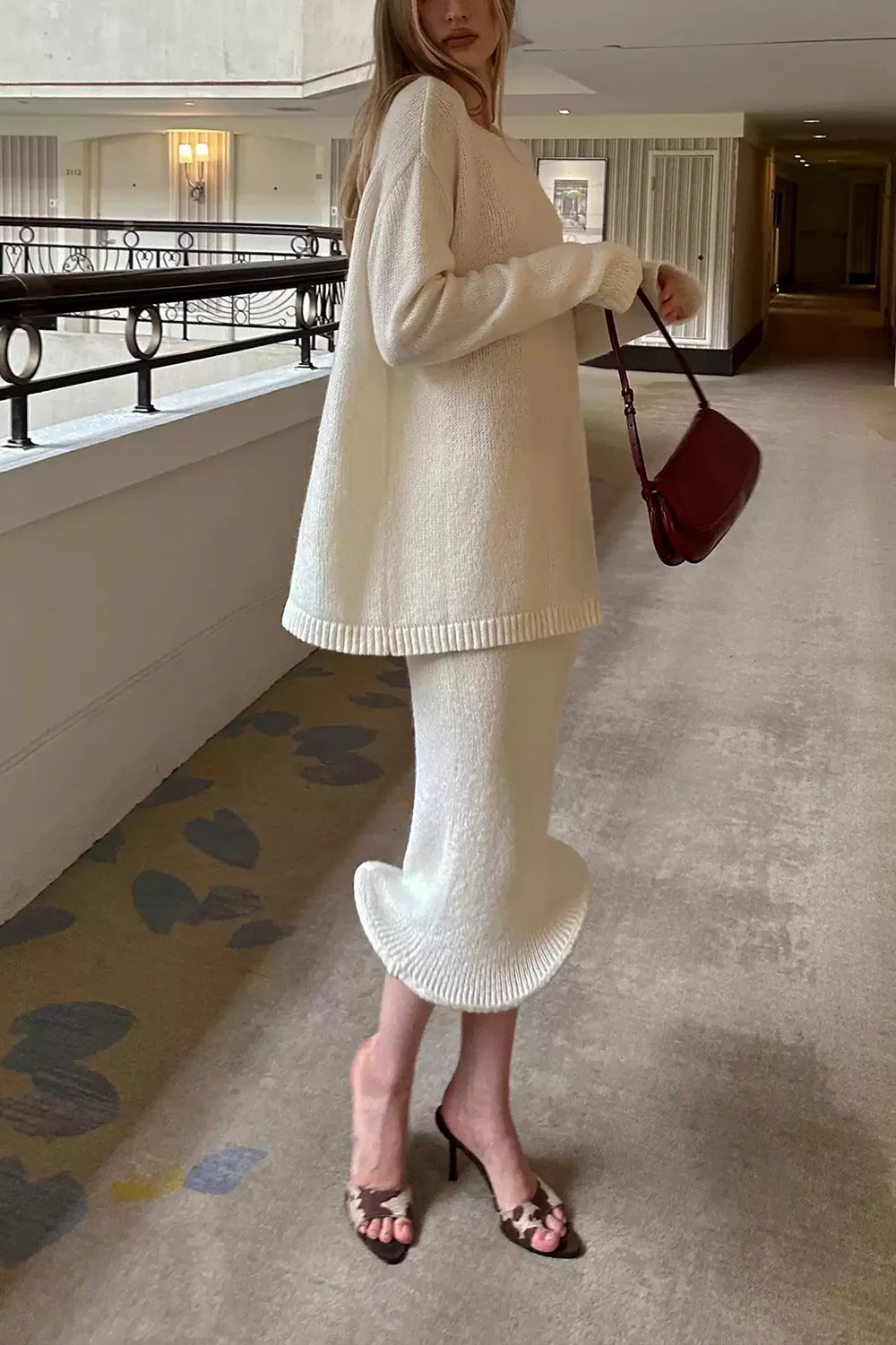 Ensemble deux pièces composé d’un pull crème en maille côtelée à col rond et d’une jupe midi à ourlet volanté