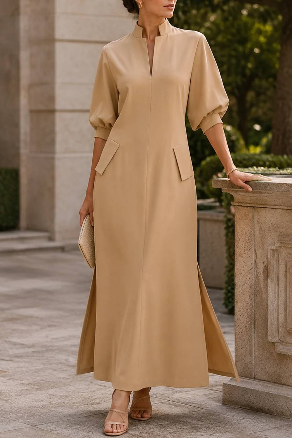 Vestido comprido com gola subida, mangas abalonadas, bolsos e racha lateral