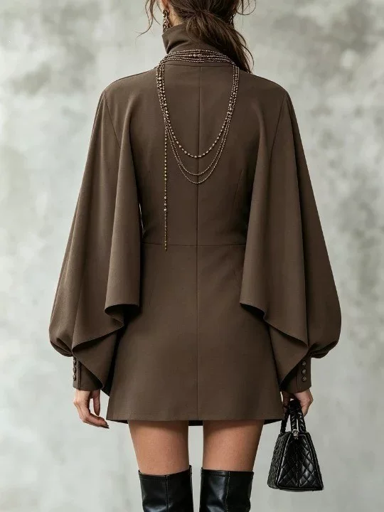 Vestido curto castanho de manga comprida, com sobreposição tipo capa, gola subida e botões à frente