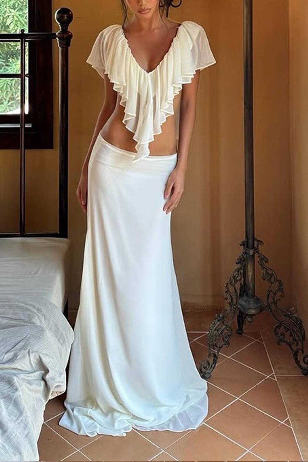 Completo due pezzi con top con scollo a V, volant e cut-out, e gonna lunga a sirena con strascico