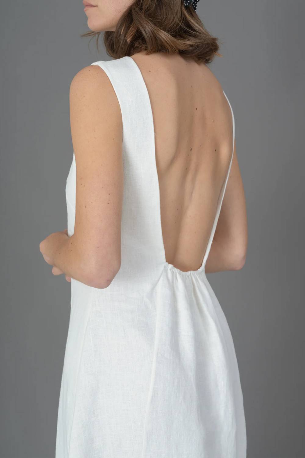 Vestido midi sem mangas, de gola redonda, franzido e com costas descobertas